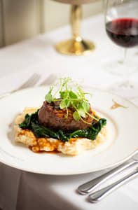 a meal at marco pierre white's london steakhouse company of steak on a layer of mashed potato and vegetables