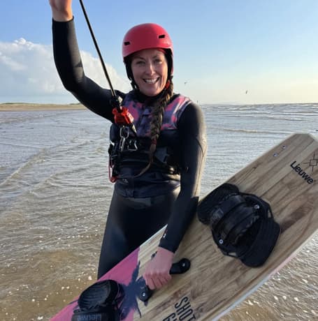 a woman on a beach on a kitesurfing lesson experience