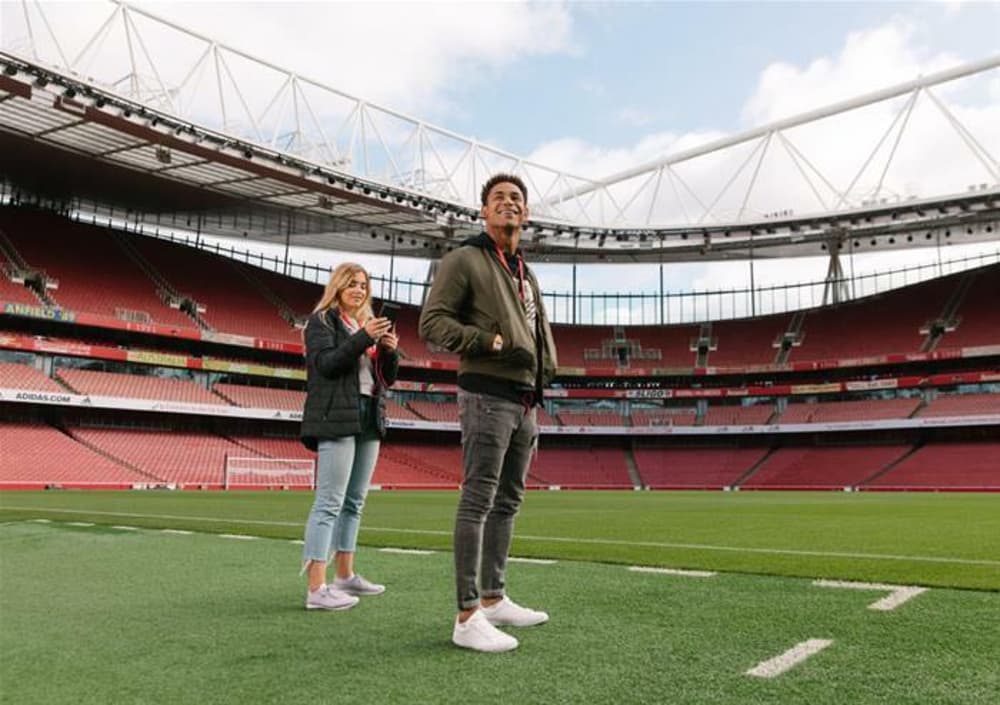 visitors on the pitch on the arsenal emirates stadium tour in london