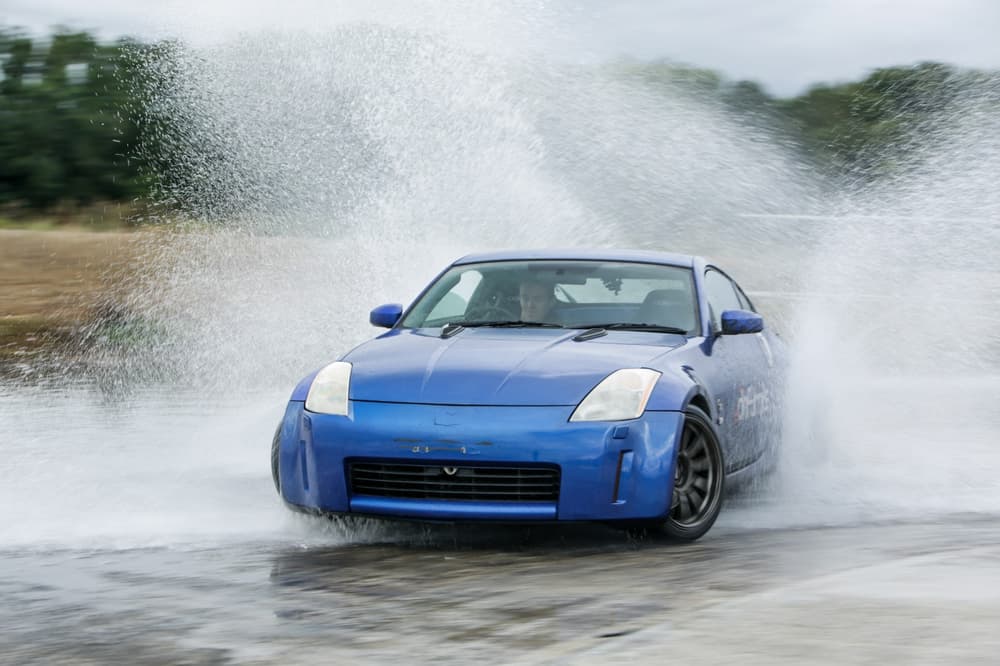 blue sports car drifting through water