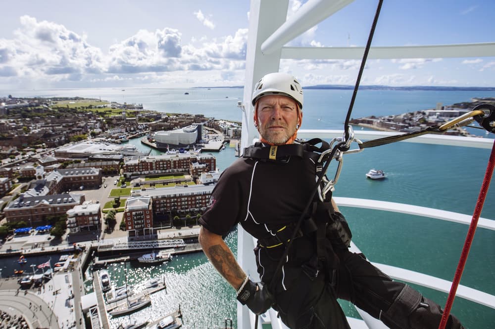 An instructor abseiling down Spinnaker Tower