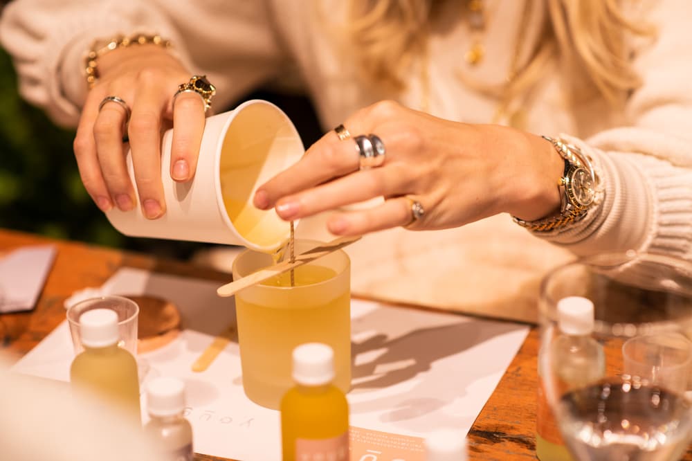 woman pouring wax into a candle jar on an aromatherapy candle workshop in london
