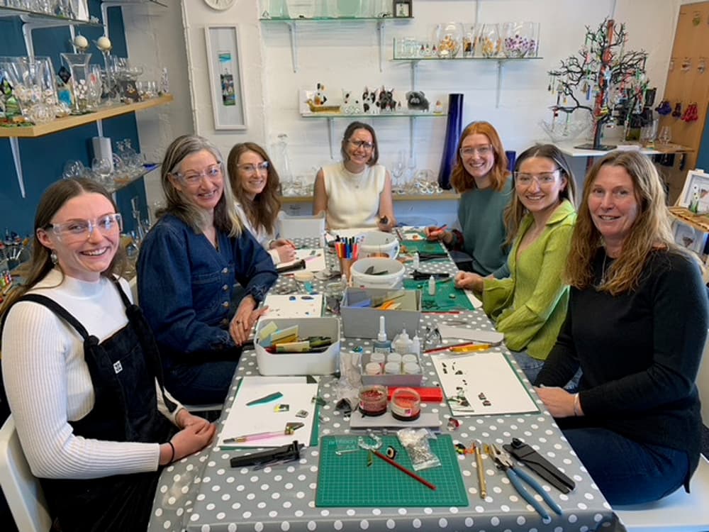 7 people around a table at a fused glass workshop