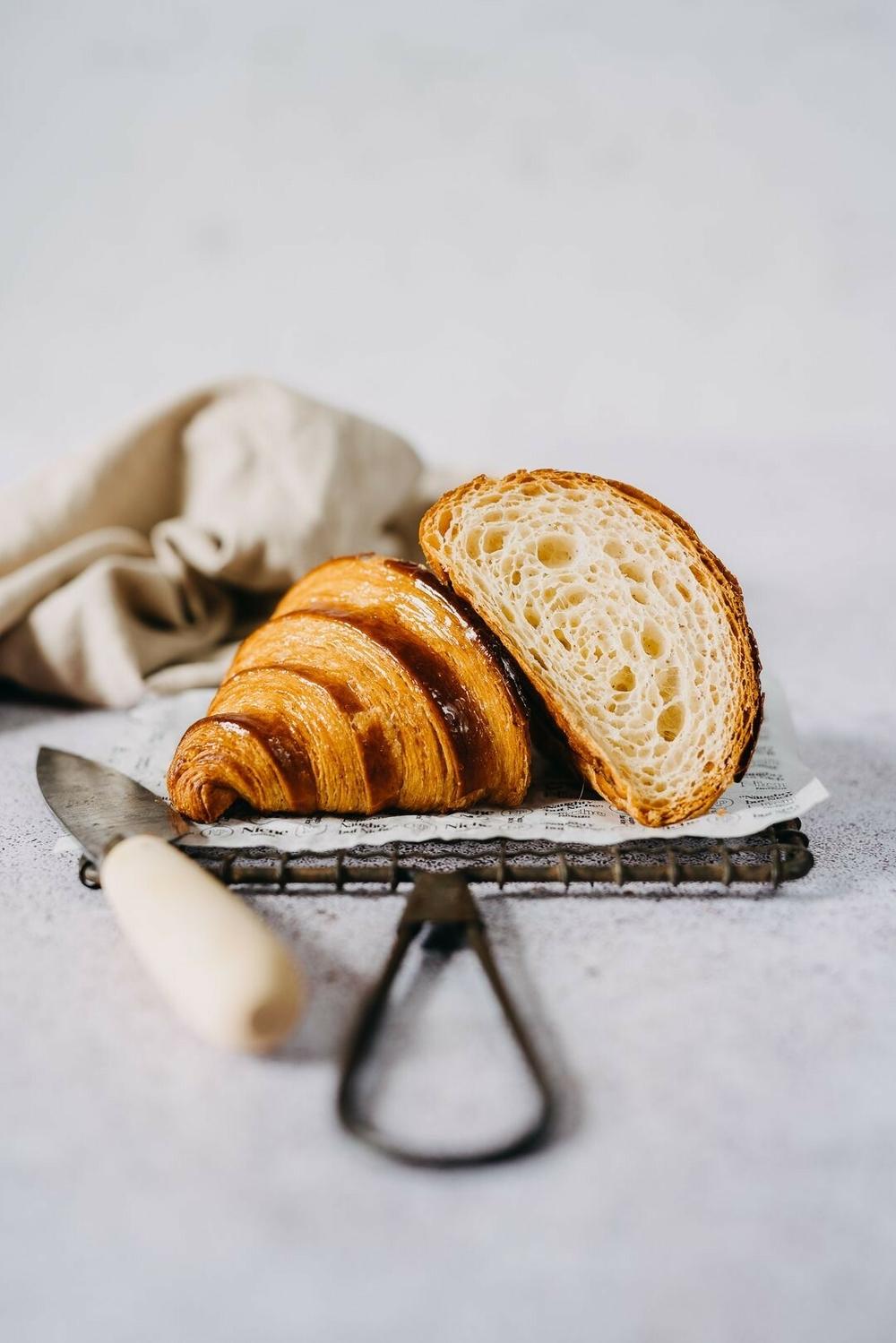 croissant cut in half to show the buttery layers for a croissant baking masterclass