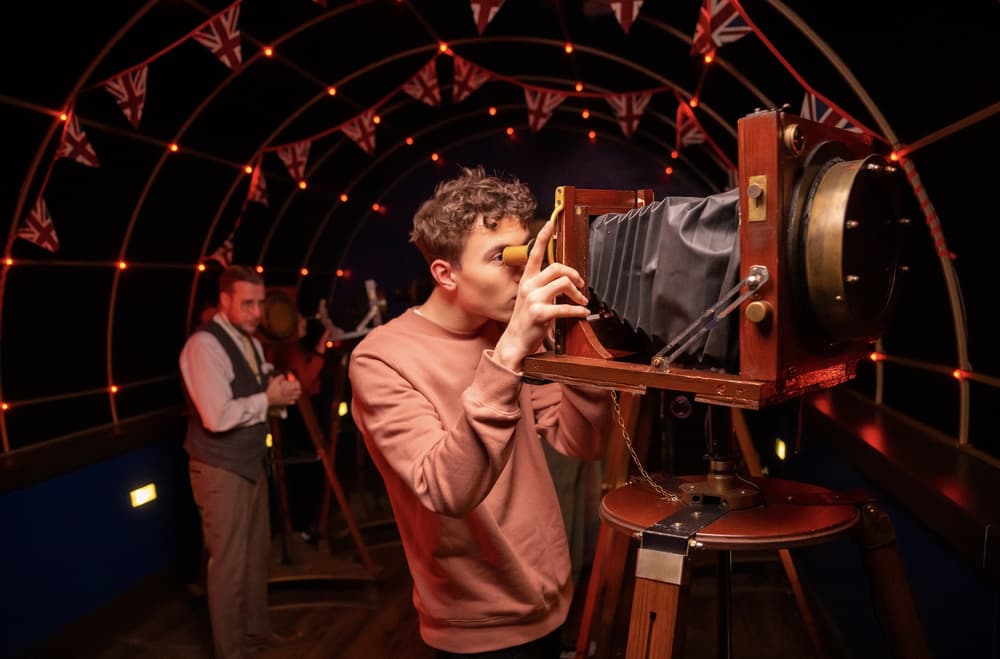 man looking through an old fashioned camera on the war of the worlds immersive experience