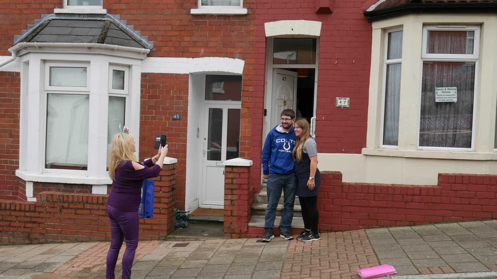 couple having their photo taken outside stacey's house on the official gavin and stacey tour experience