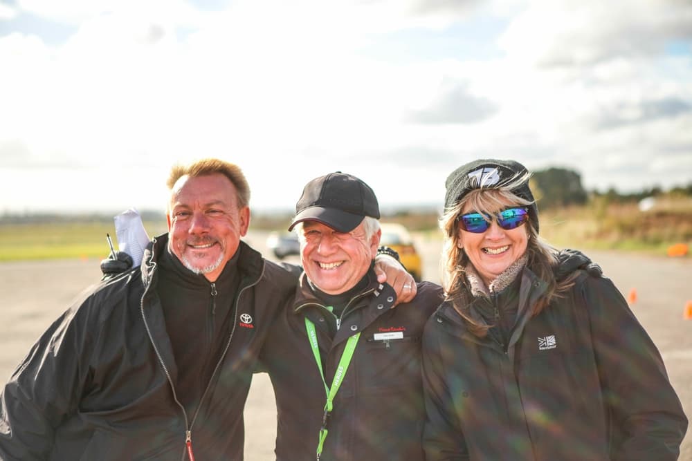 three people smiling for the camera on a driving experience day