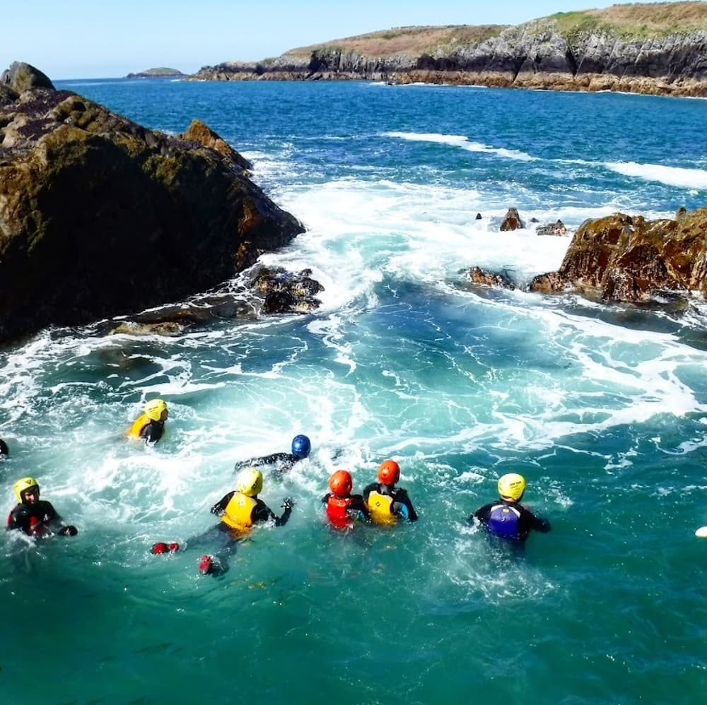 people in the sea on a coasteering experience day