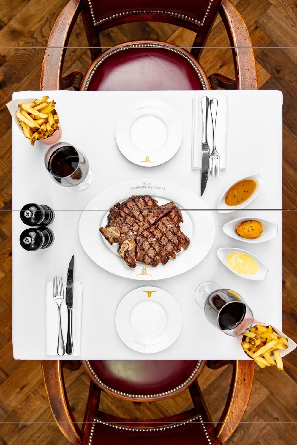 view from above of a steak dinner laid out on a table at marco pierre white porterhouse