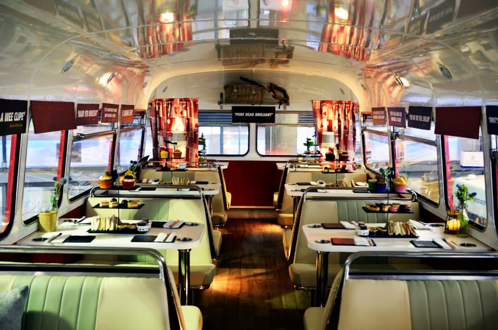 the interior of the red bus bistro set up for afternoon tea