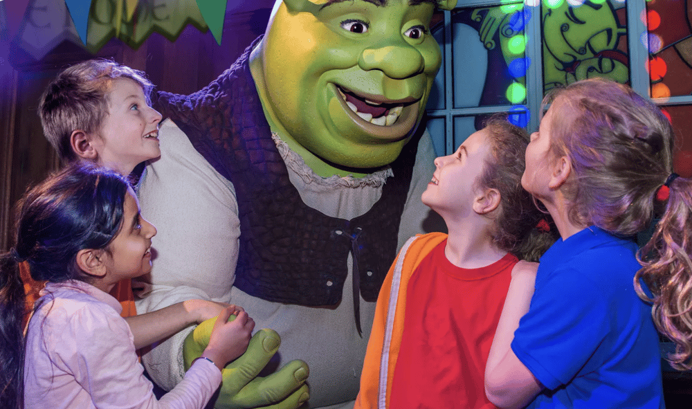 four children around a model of shrek on a visit to the shrek adventure experience