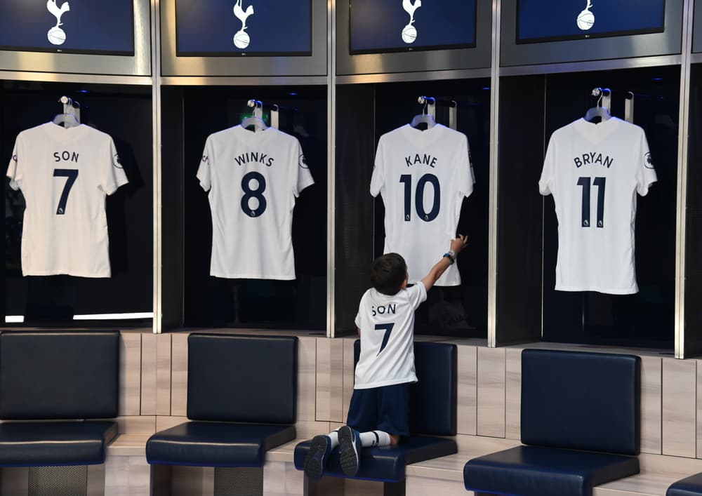 child looking at the shirts hanging in the players locker room on the tottenham hotspur stadium tour in london