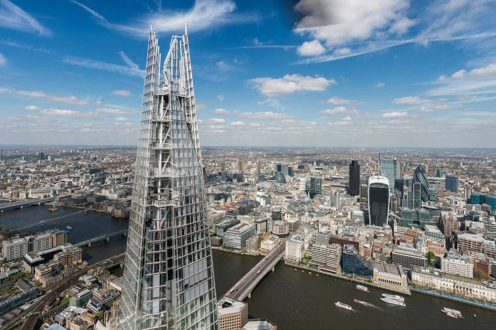 a view of the top of the shard looking out over the london skyline on a bright sunny day