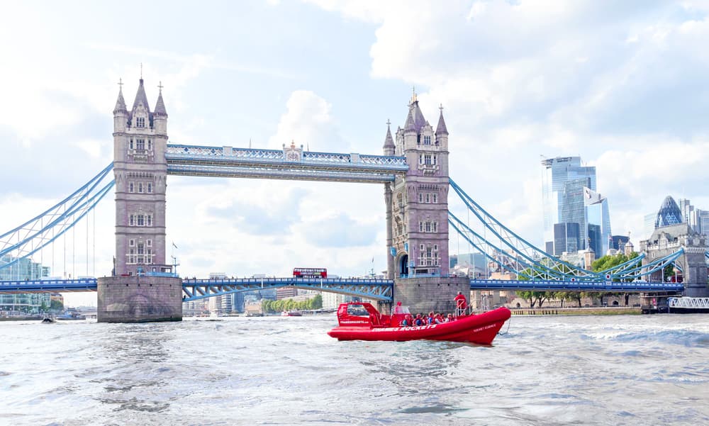 a red thames rocket speedboat on the thames with tower bridge in the background as part of a speedboat gift experience