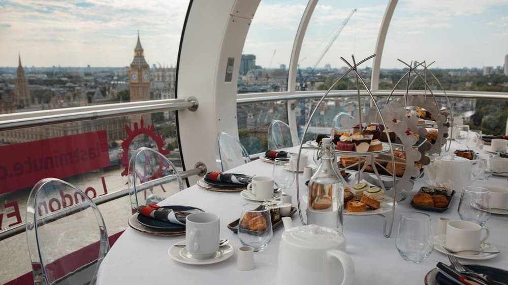 Afternoon tea laid out on a table with view of big ben on london eye