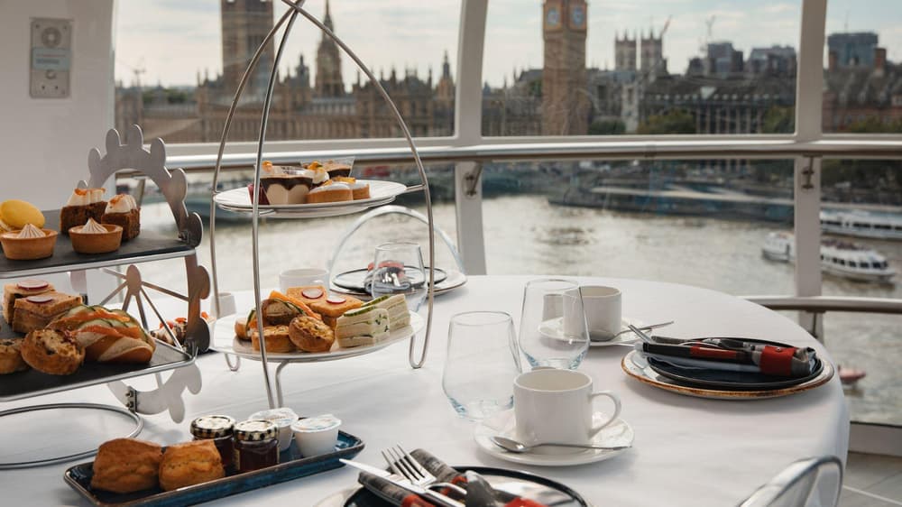 Afternoon tea on a table looking over london on the london eye