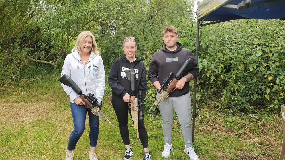 three people holding air rifles posing for photo on an air rifle shooting experience day