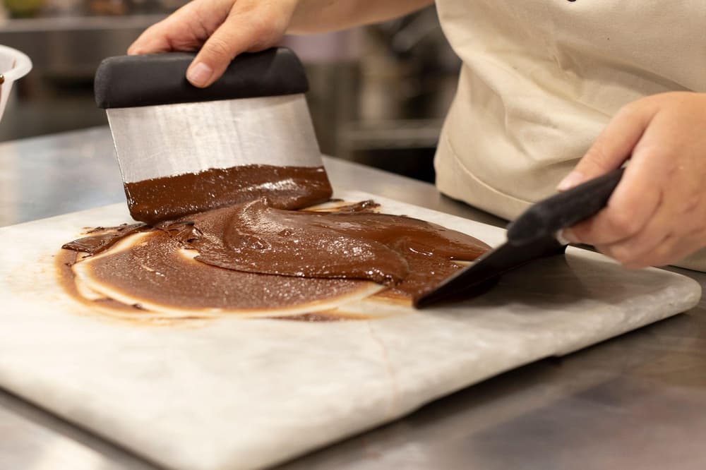 chocolate being tempered on a marble surface