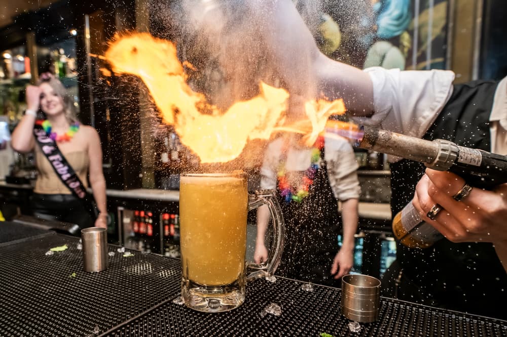 a bartender using a blowtorch on a cocktail on a cocktail masterclass at revolucion de cuba