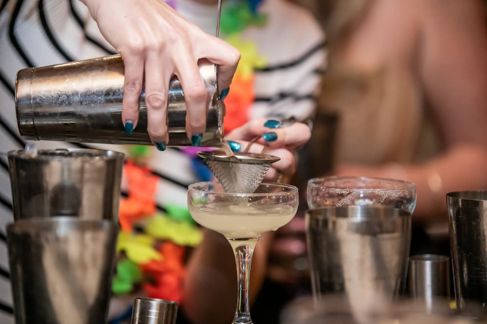a cocktail being poured into a glass on a cocktail masterclass at revolucion de cuba
