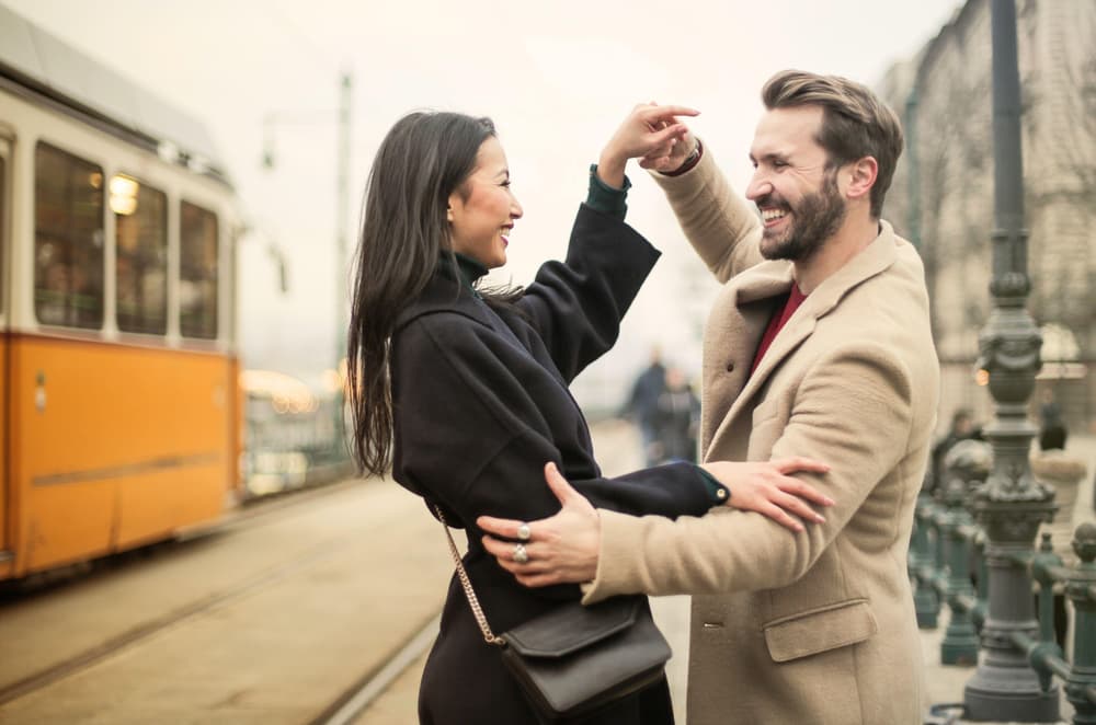 Couple in the city with a telephone box behind them