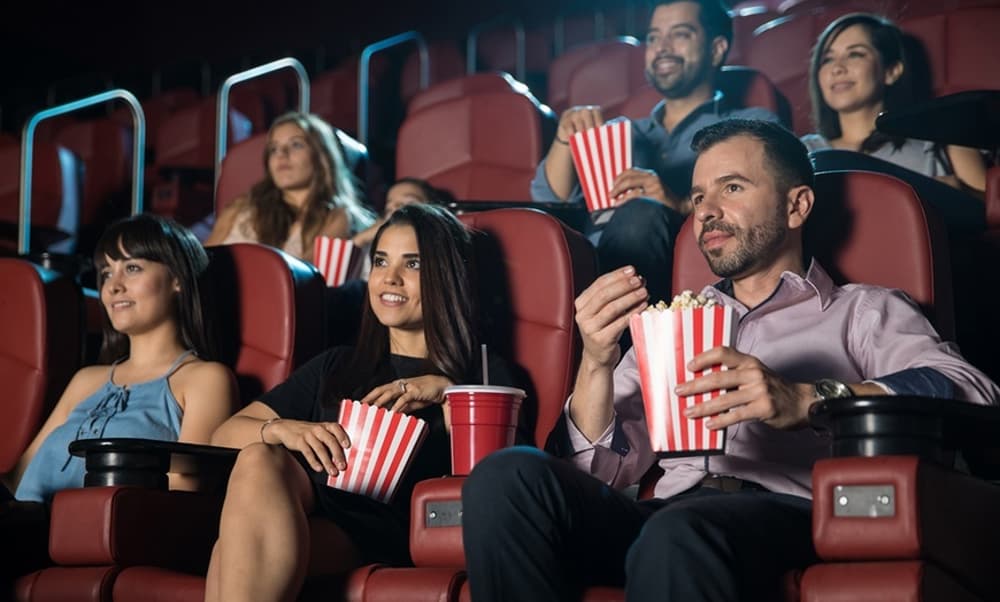 people in the cinema eating popcorn watching a film with a cinema pass for up to six people