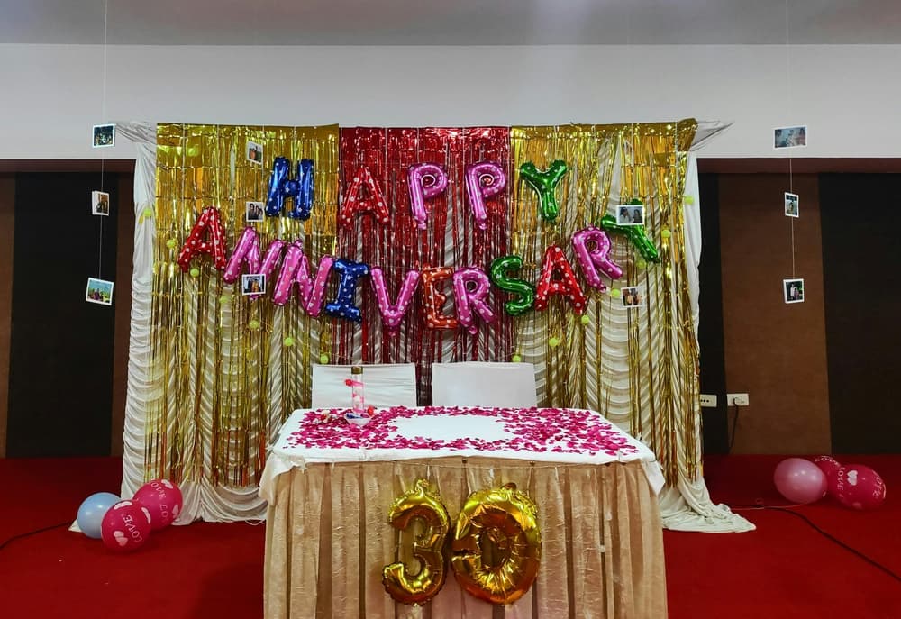 coloured balloons spelling out happy anniversary hung up on a wall