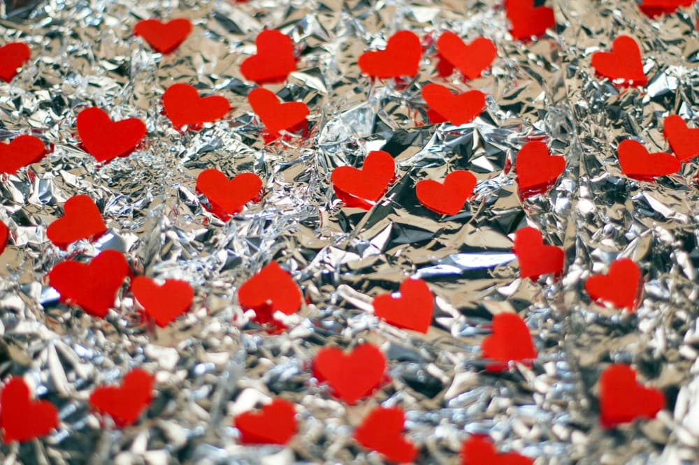 red hearts on a background of silver foil