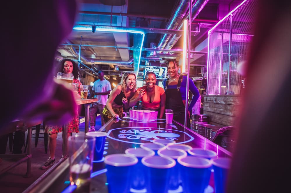 Ladies playing prosecco pong in a bar
