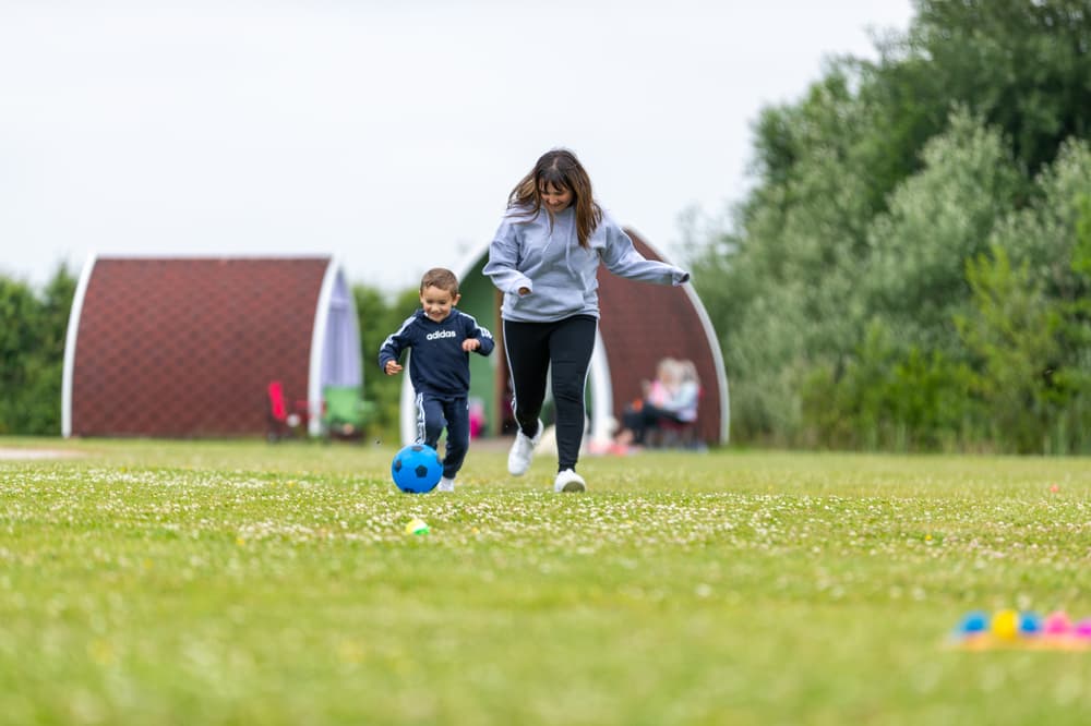Mum and son kicking a ball