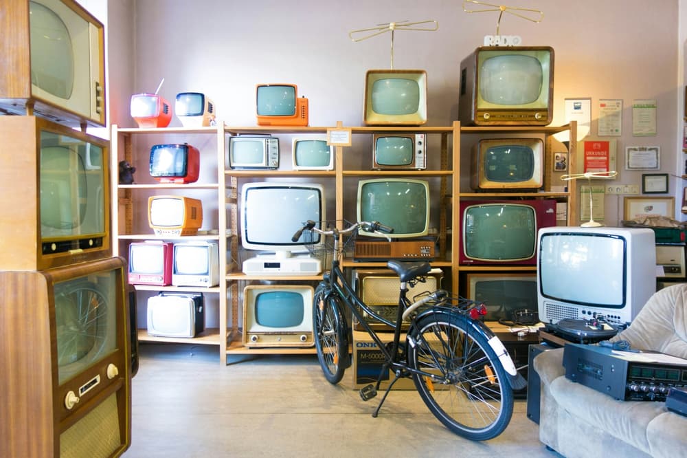 room full of old television sets and a bike