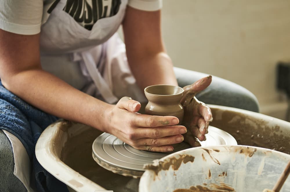 woman making pot on potters wheel on pottery experience at wedgwood