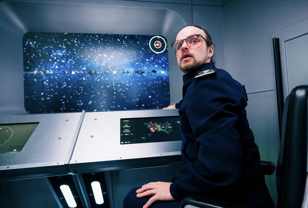 man sitting in front of computer screen on spaceship simulator experience in london