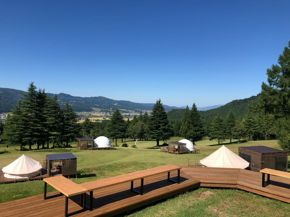 glamping set up in field surrounded by trees