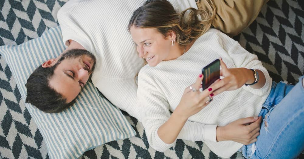 man lying on the floor with his girlfriend lying with her head on his chest spending valentines day at home