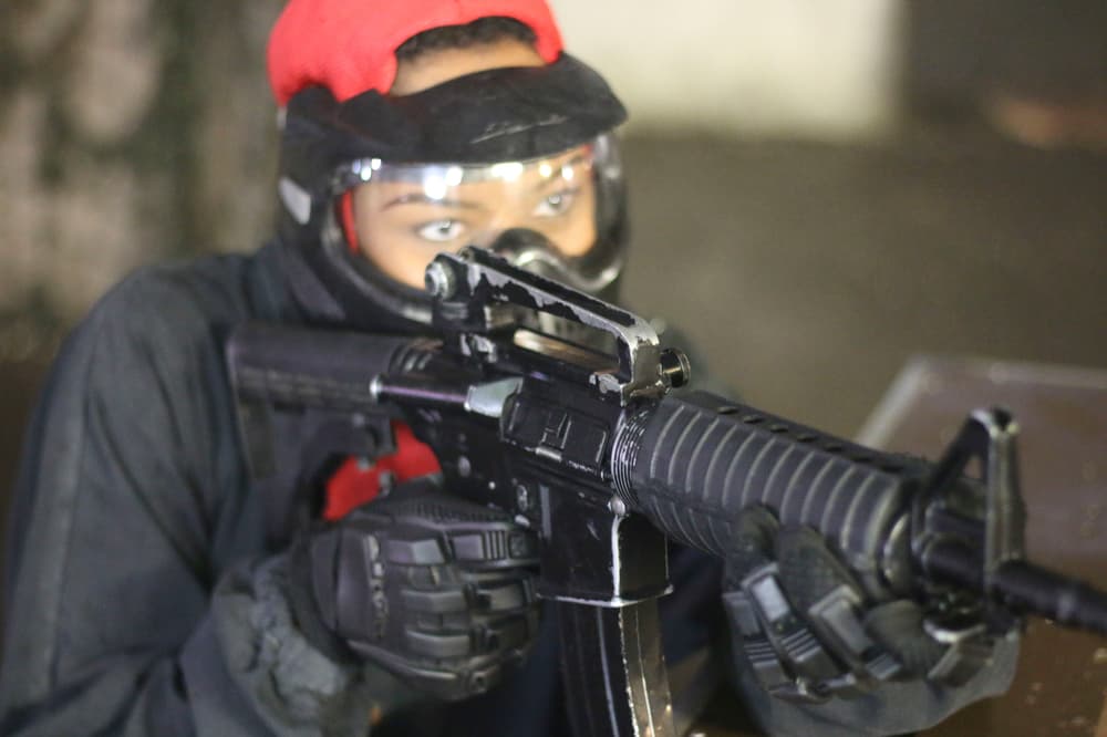 Woman aiming airsoft gun closeup