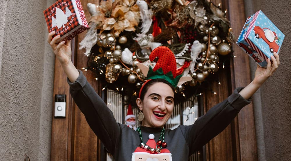 Woman dancing wearing christmas jumper and christmas tree headband