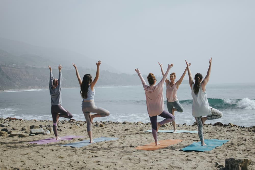 Women doing yoga on beach