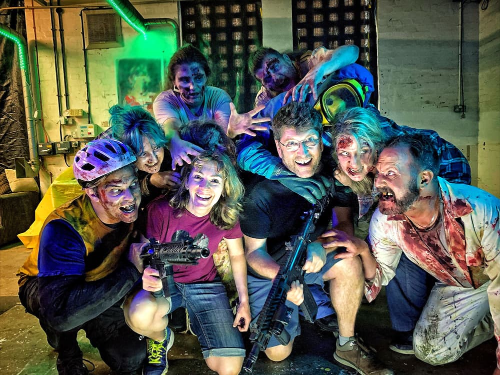 man and woman surrounded by zombies as part of a zombie immersive day out