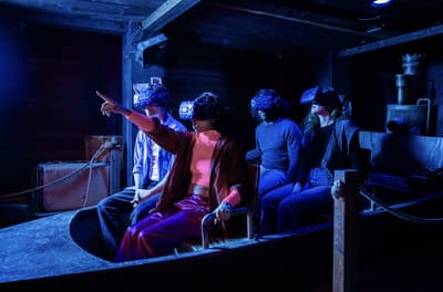 people wearing vr headsets sitting in a boat on the war of the worlds immersive experience