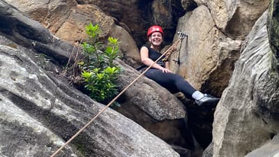 A low view of a woman sat on rocks at Climbing Exp Hatt Adventures