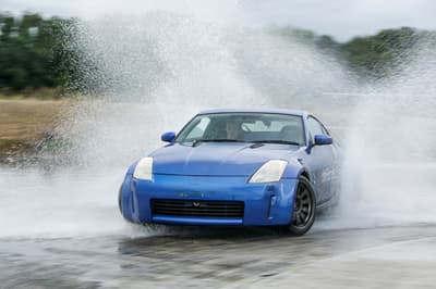 blue sports car drifting through water