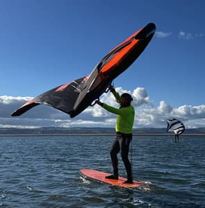 man wingsurfing on the water on a learn to wingsurf experience