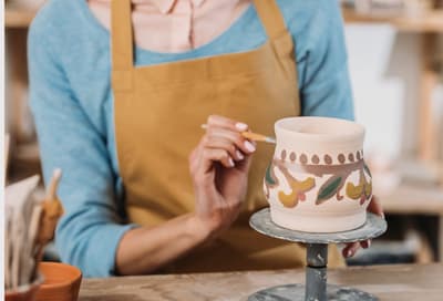woman painting a piece of pottery on a pottery painting course