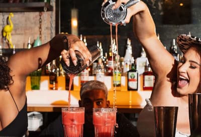 2 female bartenders pouring cocktails