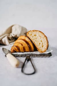 croissant cut in half to show the buttery layers for a croissant baking masterclass