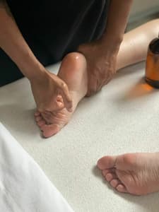 masseur massaging a clients feet as part of a reflexology treatment