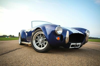 a close up of the front of a vintage sports car on a track as part of a driving experience day