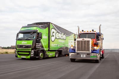 a hgv lorry and an american lorry side by side on a race track as part of a lorry driving experience
