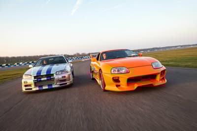 two movie inspired sports cars on a race track for a movie car track driving experience day